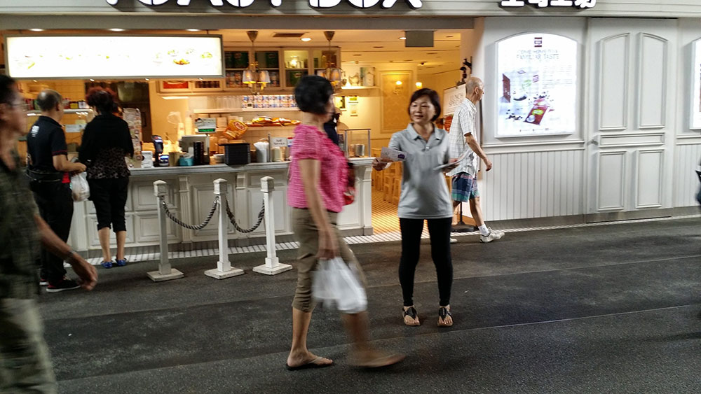High foot traffic pedestrian crossing in Singapore during peak hours, suitable for flyer distribution jobs and street marketing